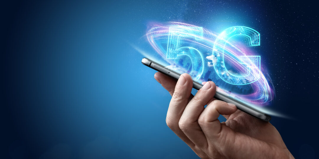 Eine Hand hält ein Smartphone, dazu leuchtet der Schriftzug 5G auf.