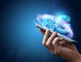 Eine Hand hält ein Smartphone, dazu leuchtet der Schriftzug 5G auf.