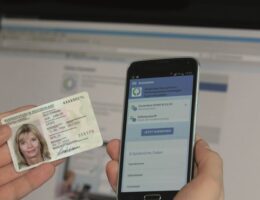 Nutzerin hält Ausweis und Smartphone bereit
