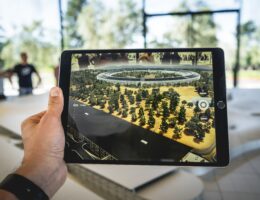 Auf einem Tablet-Bildschirm erscheinen mittels AR virtuelle Elemente auf einem Tisch.