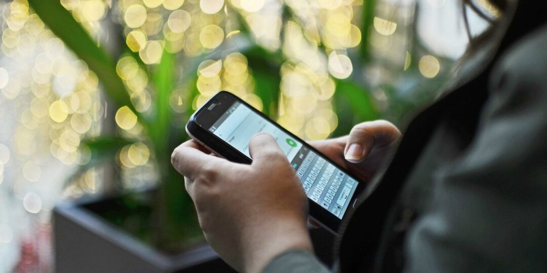 Ein Mensch chattet per Messenger auf dem Smartphone.