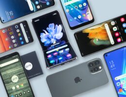 Auf einen Tisch liegen viele Smartphones in rechtwinkliger Anordnung.