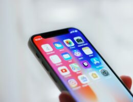 Auf einem Smartphone-Display sind mehrere App-Symbole sichtbar.