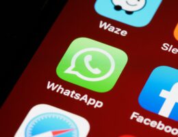 Auf einem Smartphone-Display ist das WhatsApp-Icon zu sehen.