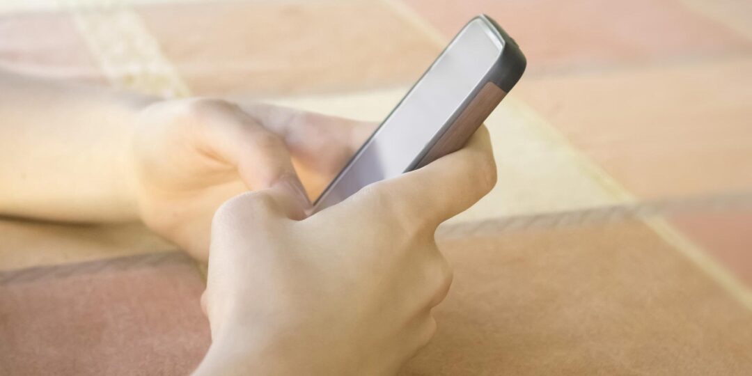 Zwei Hände halten ein Smartphone.