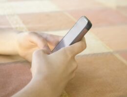 Zwei Hände halten ein Smartphone.