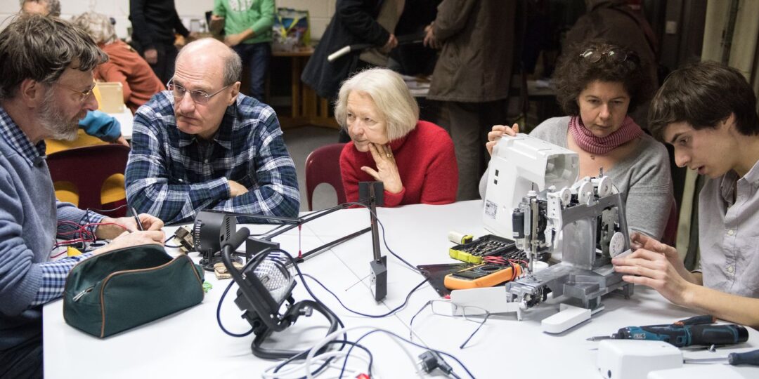 Menschen arbeiten in einem Repair Café zusammen.