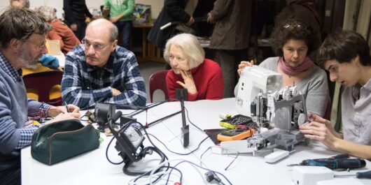 Menschen arbeiten in einem Repair Café zusammen.