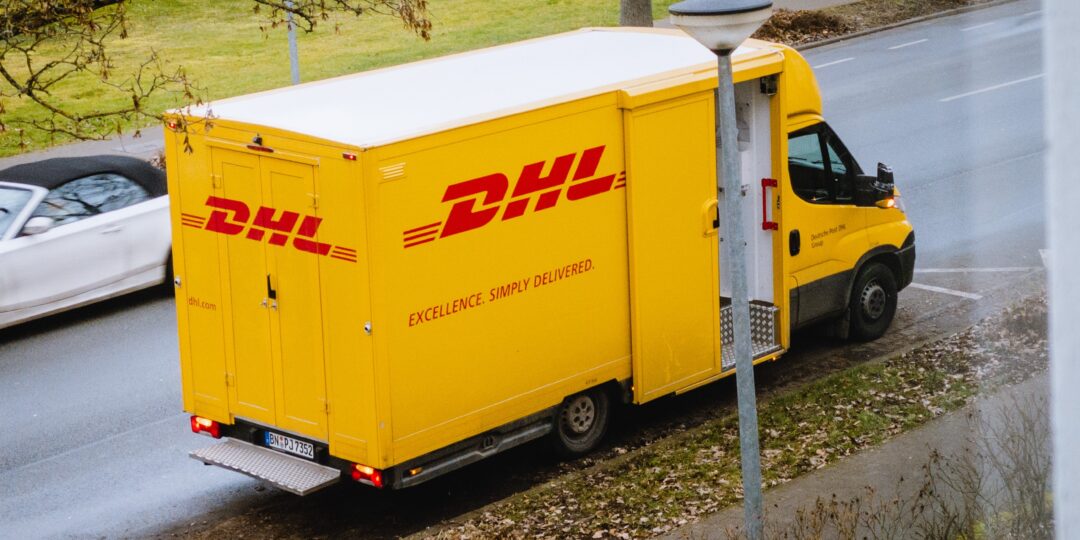 Ein DHL-Transporter hält am Straßenrand. Bild: Maxim / Unsplash