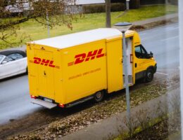 Ein DHL-Transporter hält am Straßenrand. Bild: Maxim / Unsplash