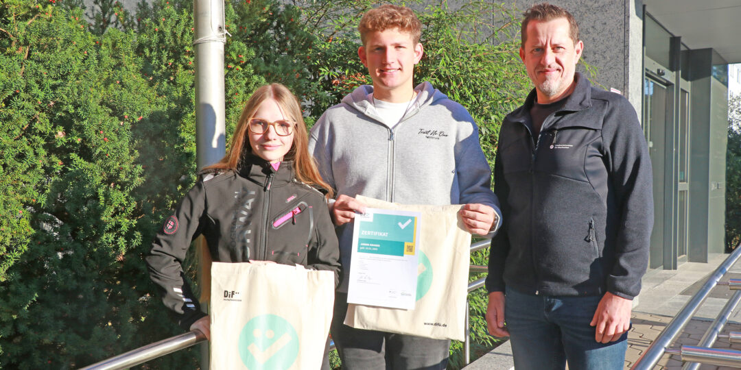 Zwei Azubis mit ihren DiFü-Zertifikaten neben Holger Bär, dem Beauftragten für Digitalisierung