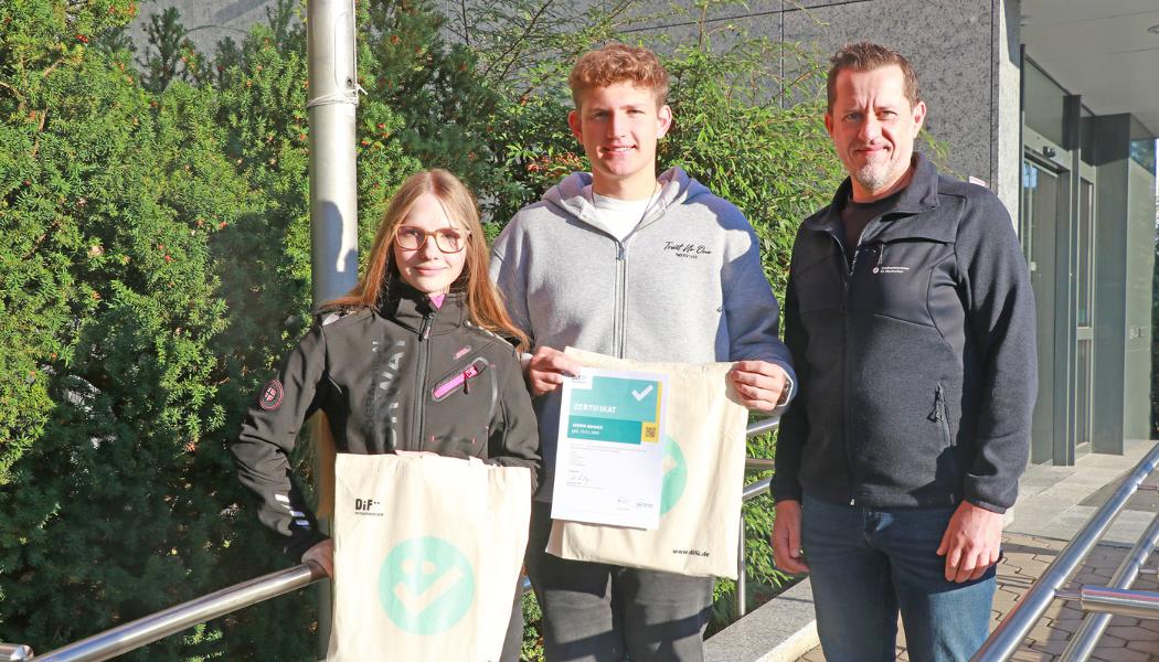 Zwei Azubis mit ihren DiFü-Zertifikaten neben Holger Bär, dem Beauftragten für Digitalisierung